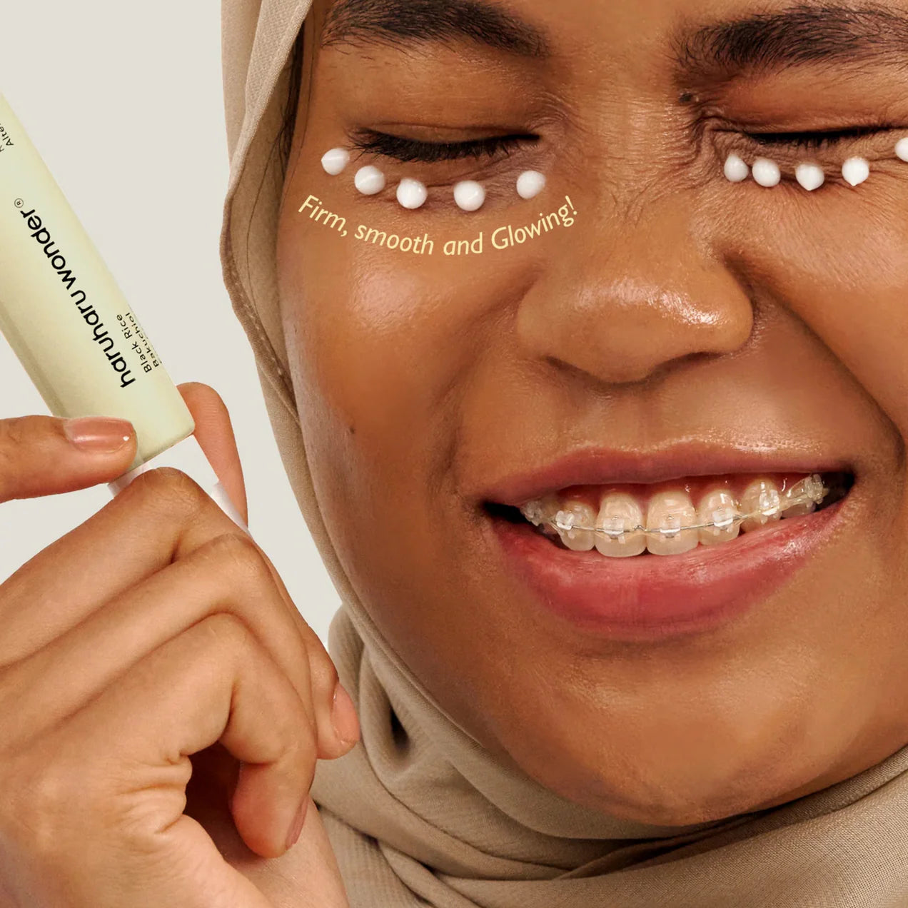 Woman applying a skincare product with text 'Firm, smooth and glowing' on her face.
