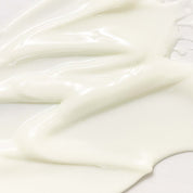 Close-up of smooth, white cream on a light background