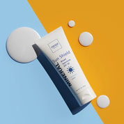 OBAQ Sun Shield sunscreen tube on a two-tone background